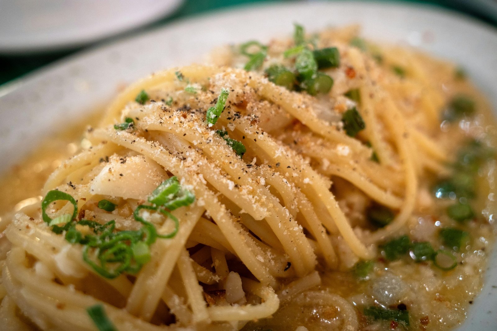 Creamy bucatini cacio e pepe being twirled with tongsr