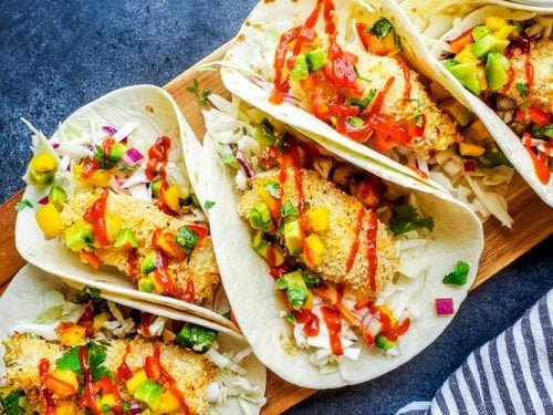 Baked fish tacos with cabbage slaw and lime crema in corn tortillas
